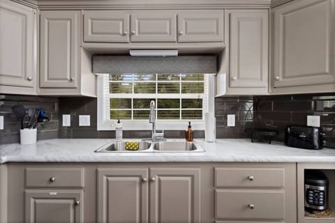 Kitchen is stocked with all necessary cooking appliances, dishware and pots and pans.