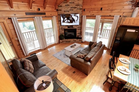 Open concept living room with views to back deck and kitchen/dining area.