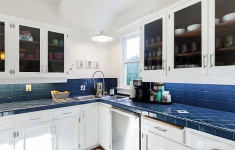 厨房 kitchen
This delightful kitchen perfectly blends classic charm with modern functionality. Featuring striking blue tile countertops and backsplash, the space offers a unique and timeless aesthetic. The crisp white cabinetry with glass-front doors provides both style and practicality, offering plenty of storage while keeping essentials within easy reach.