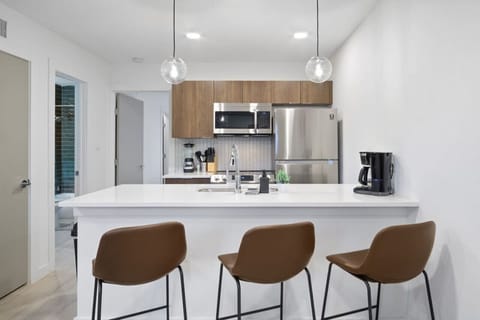 This contemporary kitchen is a chef's dream, featuring a large island, modern stainless steel appliances, and sleek cabinetry. The open layout ensures you can cook and entertain effortlessly, making it the perfect space for culinary creativity and social