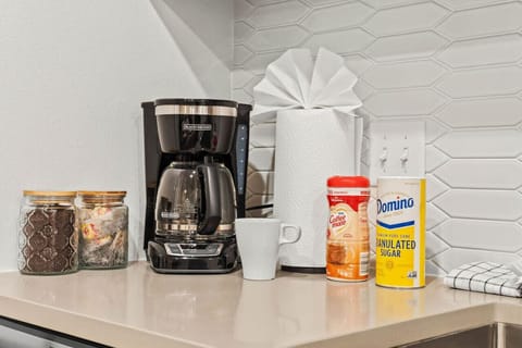 The coffee station is thoughtfully equipped with a variety of in-house consumables, including a selection of ground coffee, sweeteners, and creamers to suit every taste.