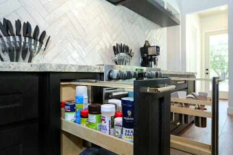 Enjoy a fully stocked kitchen with pull-out spice racks and top-tier appliances, designed for effortless meal prep.