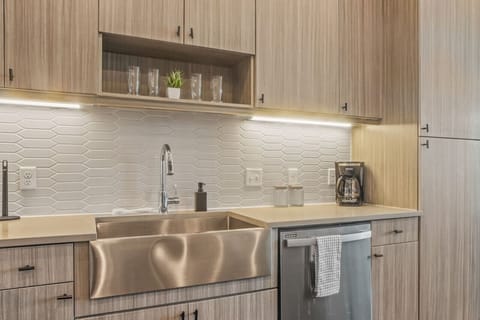 This contemporary kitchen is a chef's dream, featuring a large island, modern stainless steel appliances, and sleek cabinetry. The open layout ensures you can cook and entertain effortlessly, making it the perfect space for culinary creativity and social