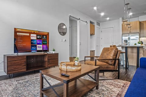 Bright and airy living room with plush seating, a large TV, and tasteful decor, creating the perfect space for relaxation and entertainment.