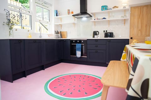 Kitchen with base cupboards and open shelves. Table and chairs