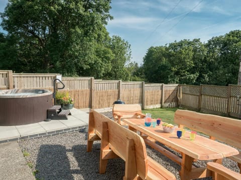 Wooden table and chairs, hot tub in fenced garden