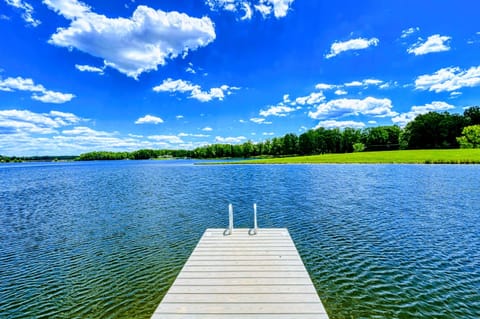 Picturesque dock extending into a clear, tranquil lake under a vibrant blue sky, perfect for a refreshing swim or peaceful retreat