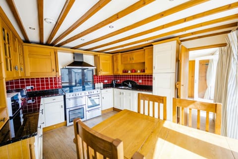 Fitted kitchen, large range style oven, sink, microwave, table and chairs