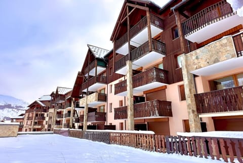 This charming apartment is part of a quaint ski resort building, nestled amidst the snowy peaks of the French Alps. The building features a traditional alpine design with wooden balconies and stone accents, creating a cozy and inviting atmosphere. The apa