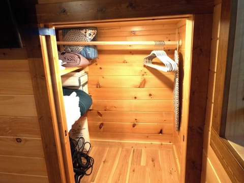 Bedroom closet with hangers and shelves with extra linens