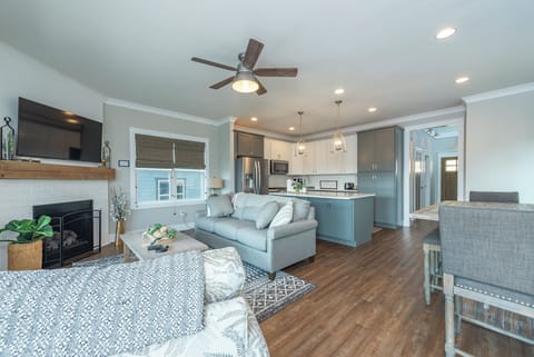Living room with gas log fireplace, 55" Smart TV for streaming, and access to the covered deck.