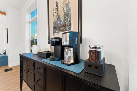 Coffee bar with starter coffee grounds, filters, K cups, creamer, sugar, flavored syrups. 12-cup traditional and Kurig coffee makers.