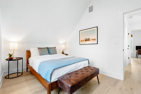 The stylish second bedroom offers a full bed & ottoman