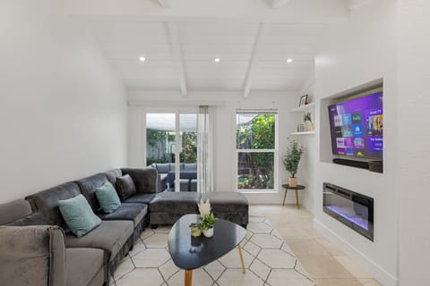 Modern living room with plenty of natural light, featuring a sleek media wall