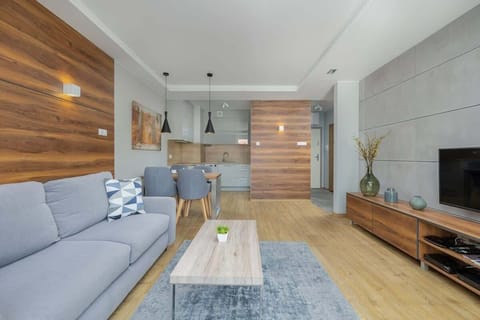 Spacious living area with gray furniture, wood paneling, and a cozy atmosphere.