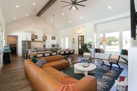 Spacious living area with modern kitchen, large sectional, and cozy seating nook.