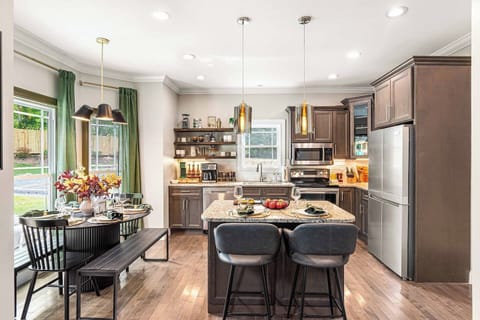 Gather around this spacious kitchen island and enjoy a meal in the bright dining area. A modern and welcoming space, perfect for family breakfasts or evening feasts.