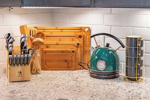 Prepare your meals with ease in this modern kitchen, fully stocked with premium utensils and a charming teal kettle for that perfect cup of tea.