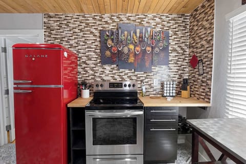 Full kitchen stocked with utensils, cookware and dishes.