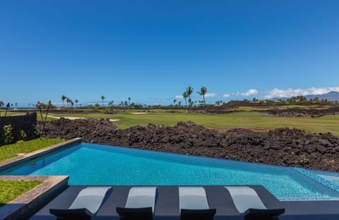 Enjoy a refreshing dip in the pool with a serene golf course view, perfect for a sunny afternoon.
