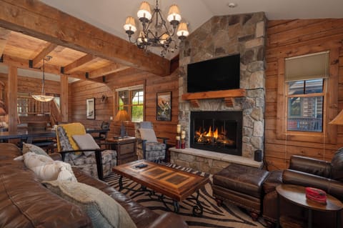 - Cozy living room with stone fireplace and wood beams - Plush seating and smart TV for relaxing nights indoors - Rustic cabin charm with warm lighting and decor