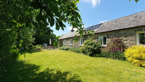 Large lawn area with mature shrubs and flower beds
