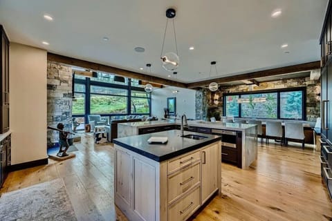 Enjoy cooking and dining in this expansive, light-filled kitchen with top-tier appliances, an oversized island, and panoramic windows offering stunning views of the surrounding nature.