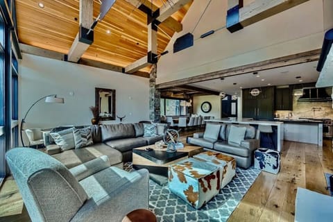 Gather in this expansive living room featuring ample seating, high ceilings, and a cozy atmosphere—ideal for family relaxation and entertaining with stunning views