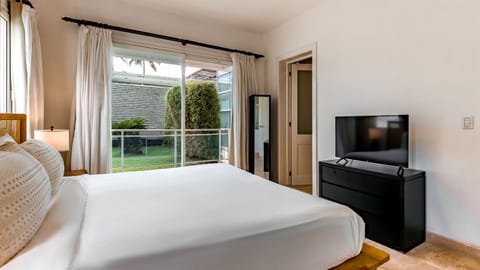 Unwind in the master bedroom featuring a plush bed King size bed, ocean breeze, and a flat-screen TV perfect for relaxing after a day at the beach each in your private, modern retreat.