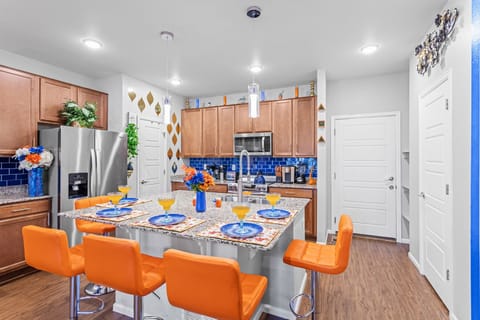 This stylish kitchen combines rich wood tones with vibrant blue tiles, offering a cozy yet contemporary dining space