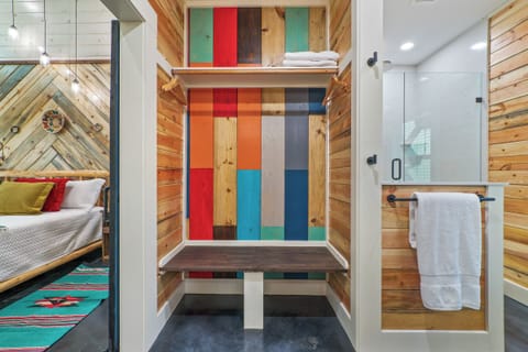 Colorful bathroom entry with custom wood accents and walk-in shower
