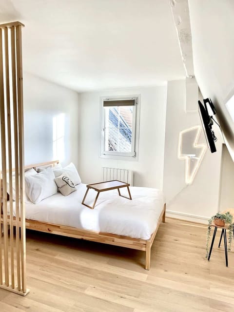 Chambre avec lit double et télévision murale HD.
La chambre est semi ouverte sur l'espace repas et cuisine.