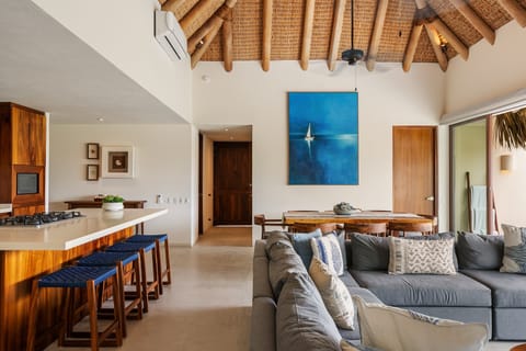 Stylish open-concept layout with a gourmet kitchen and comfortable lounge area overlooking the sea and tropical gardens.