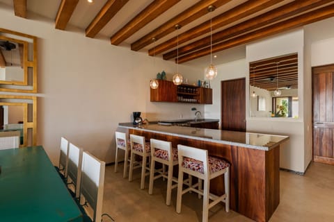 A fully equipped kitchen with handcrafted wood finishes, stylish lighting, and a spacious island with bar seating.