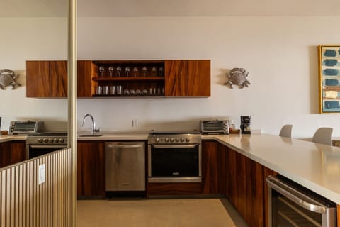 A fully equipped kitchen with high-end appliances, open shelving, and rich wooden cabinetry for a sleek and functional design.