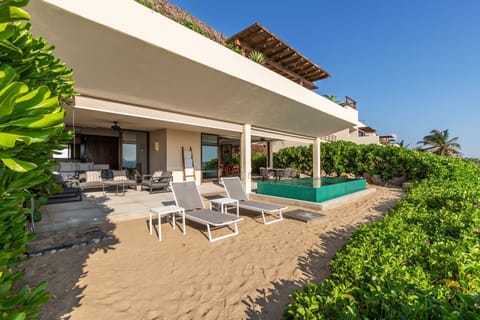 Step onto the sand from this luxurious villa, featuring a private pool, spacious terrace, and stunning ocean views.