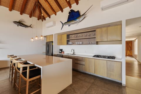 A spacious and elegant kitchen featuring high-end appliances, a large island with bar seating, and beautiful wooden finishes.