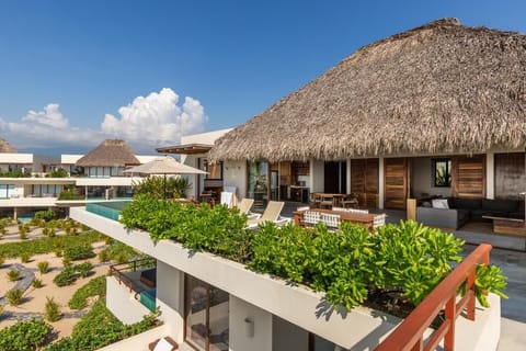 Experience the height of luxury in this penthouse villa featuring a private infinity pool, lush greenery, and expansive ocean views.