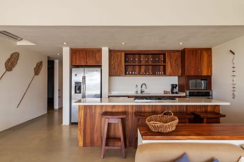 This chef's kitchen boasts high-end appliances, custom wood cabinetry, and a spacious island for dining and entertaining.
