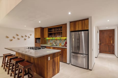 Cook with ease in this modern kitchen with local tile accents, a spacious island bar, and handcrafted wood cabinetry—ideal for family meals.