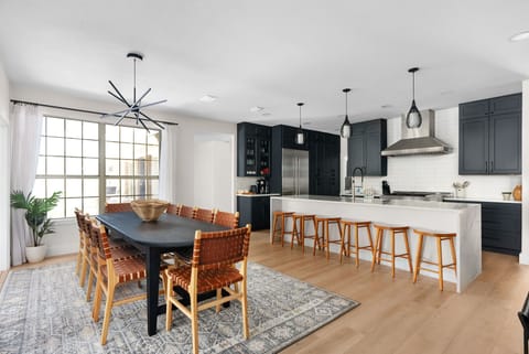 Gather 'round! Our kitchen has a stunning long table and ten cozy seats! 🪑✨ Plus, we’ve added six extra bar stools at the kitchen island for those casual hangouts.