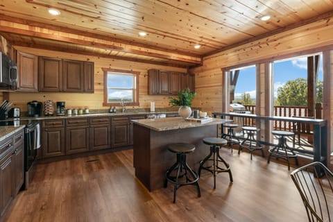 Fully equipped chef’s kitchen with granite countertops and bar seating.