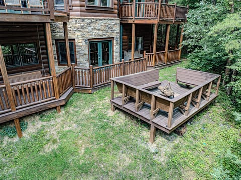 Spacious wood-framed fire pit area with built-in bench seating—perfect for evening gatherings.