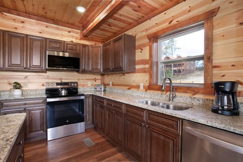 Fully equipped modern kitchen with granite countertops and rustic cabin charm