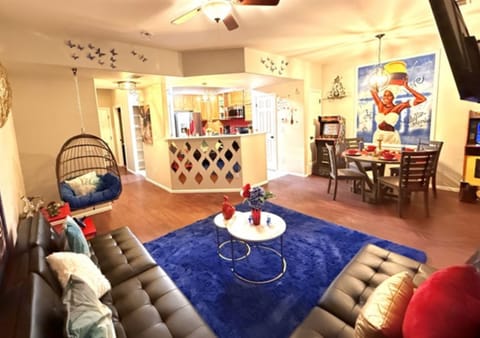 This kitchen showcases warm wood cabinets, dark granite counters, and a bold red tile backsplash with stainless steel appliances. Decorative elements and plants add charm and warmth to the spa