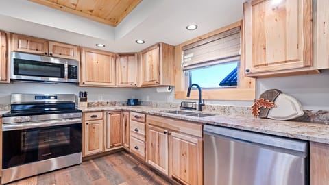 Cozy kitchen with natural wood cabinets, modern appliances, and scenic views.