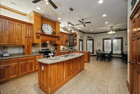 Full kitchen with walk in pantry, two dining tables, island bar and office space