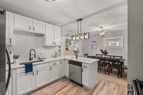 Savor culinary moments in this modern kitchen, seamlessly flowing into an elegant dining area—perfect for gatherings and gourmet experiences.