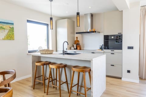 Cook in style in this fully equipped kitchen with a central island, designer lighting, and top-quality appliances.