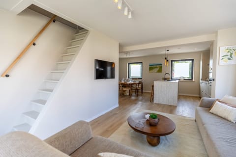 Bright, open-plan layout with modern design, hardwood floors, and natural light - designed for relaxing getaways and long stays by the sea.